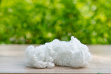 Polyester stable fiber on wooden plank with green blurred background