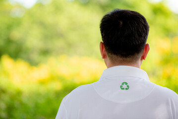 Men wear shirts made from PET bottles or recycled materials and have the Recycle symbol on the shirt with green blurred background.