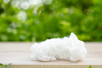 Polyester stable fiber on wooden plank with green blurred background