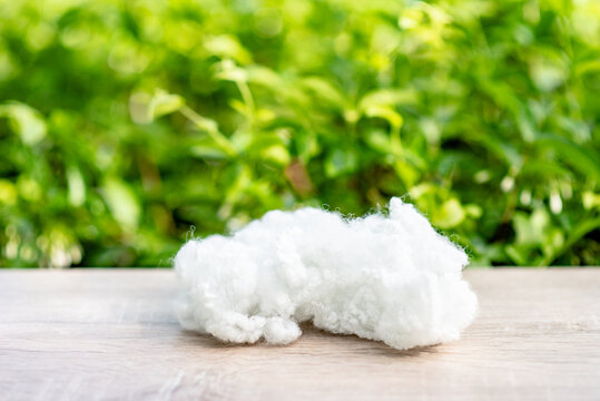 Polyester stable fiber on wooden plank with green blurred background