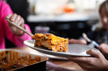 Mother serving homemade vegan lasagna