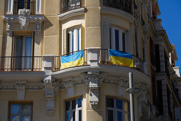 the flag of Ukraine on the facade of a building in Madrid, Spain.