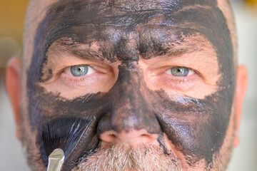 Extreme close up the face of a man wearing a cosmetic face mask