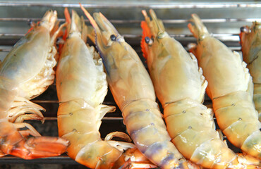 Grilled prawns on flaming grill.