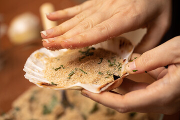 Hand flatten food mixture in seashell