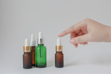 Woman hands holding facial essential oil or serum packaging on white background. Beauty cosmetic product for skincare concept.