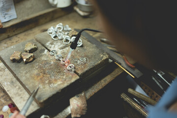 Jeweler at work in jewelry. Desktop for craft jewelry making with professional tools. Close up view of tools. Silver jewelry. Unique local artwork in Nan Province northern thailand
