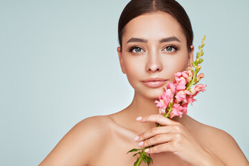 Portrait beautiful young woman with clean fresh skin. Model with healthy skin, close up portrait. Cosmetology, beauty and spa. Girl with a pink  flower