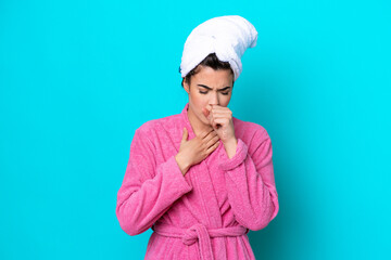 Young Brazilian woman with a bathrobe isolated on blue background is suffering with cough and feeling bad