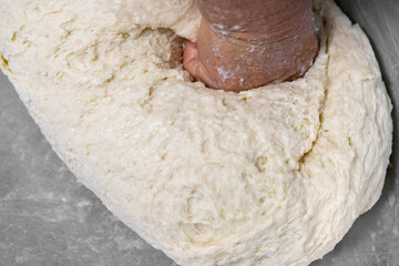 The old man's hand is kneading the dough