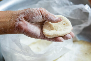 The old man's hand is kneading the dough