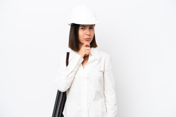 Young architect woman with helmet and holding blueprints isolated on white background thinking
