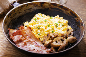 Pan of scrambled eggs, bacon and mushrooms