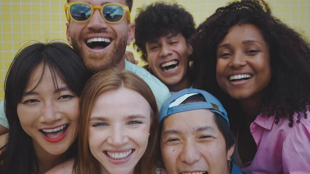 roup of friends having fun on the beach. Multiethnic Teenagers having a good time during the summer celebrating together next to the ocean.