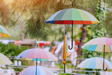 Fototapeta na wymiar Hanging colorful umbrellas in city park as decoration