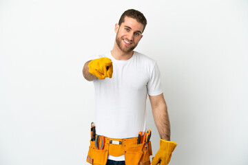 Young electrician man over isolated white wall pointing front with happy expression
