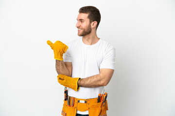 Young electrician man over isolated white wall pointing to the side to present a product
