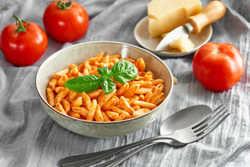 Cavatelli pasta in tomato sauce on the tablecloth