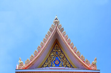 Naklejka premium Part of the Roof of a temple in Thailand. Traditional Thai style pattern on the roof of a temple with Blue Sky Background.