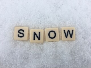 Word snow spelt out on white snowy background