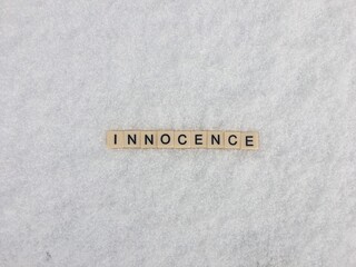 Word innocence spelled out on snowy white background 