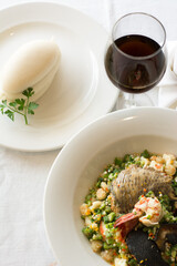 A top view of the Nigerian delicacy Okra soup prepared majorly with seafood served with fufu / pounded yam and wine