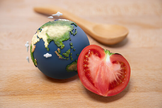Half of tomato and a globe on the wooden table.
Happy earth day.
