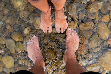 father and son wet their feet in the water
