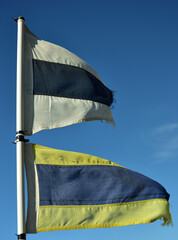 The third repeater and keep clear marine flags on a boat flapping in the wind