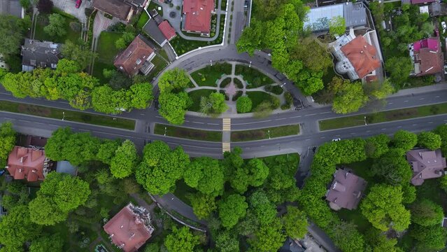 Top down aerial view of car drive at downtown street with small buildings and trees in Amalienau district, Kaliningrad, Russia. 4k drone video