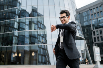 The manager looks at the clock a man with glasses goes to the office to work, in a business suit