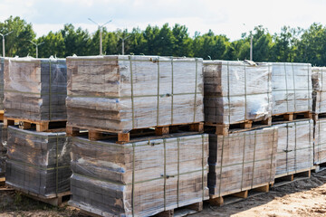 Storage of paving slabs on pallets at the construction site. Ready-to-install concrete paving slabs. Finished products warehouse.