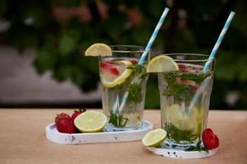 Colorful infused water with lemon, lime, mint and strawberries. Healthy natural summer cocktails....