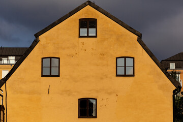 Fototapeta na wymiar Stockholm, Sweden An old yellow house facade and windows on Graverska Huset on Kungsholmen.