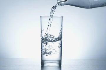 Image of pouring water from a water bottle into a glass