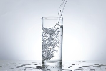 Image of pouring water from a water bottle into a glass