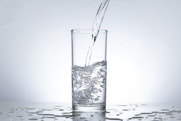 Image of pouring water from a water bottle into a glass