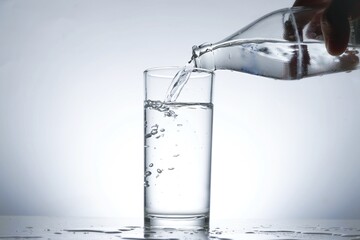 Image of pouring water from a water bottle into a glass