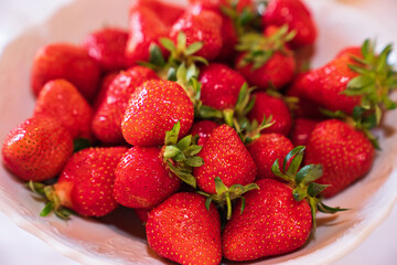 ripe and fresh strawberries in a white plate. healthy and delicious dessert. natural farm products. seasonal berry.