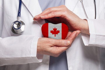 Canadian doctor holding heart with flag of Canada background. Healthcare, charity, insurance and...
