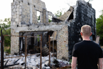 Man looking to his ruined and burnt house by russian troops.