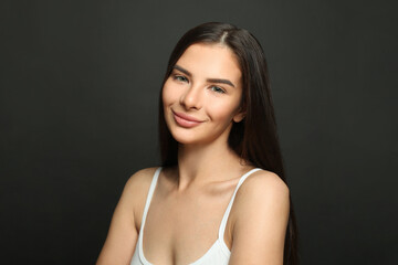 Cute smiling woman looking at camera on black background