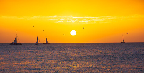 Golden Orange Sunset Across the Atlantic Ocean with Boats and Seagulls Far Away