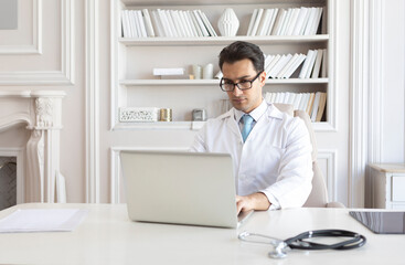 Young male doctor working in the office