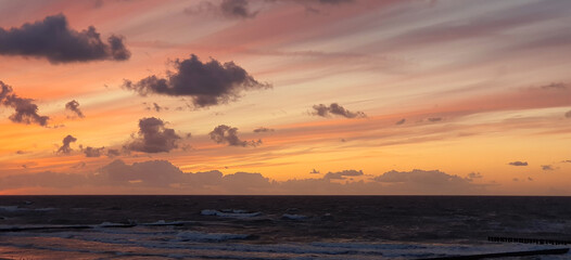 Fototapeta premium the black baltic sea and the red-orange sky above it