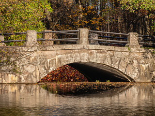 St. Petersburg in autumn, a natural monument landscape park "Sergievka". A pond and an old stone bridge.