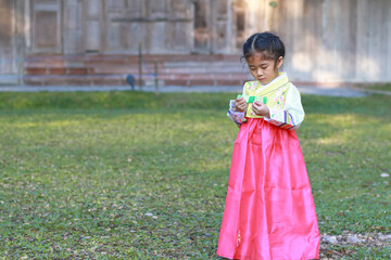 Asian children in national costumes. Lovely kid girl with Korean hanbok dress.