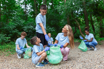 Group of volunteers cleaning up forest from waste, community service concept