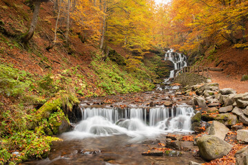 Amazing Waterfall view in autumn forest. The autumn colors surrounding the waterfall Guk in Ukraine