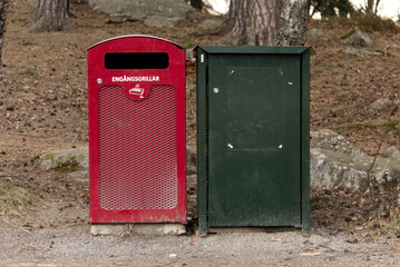 a dark green trash can and a red emtal trash can